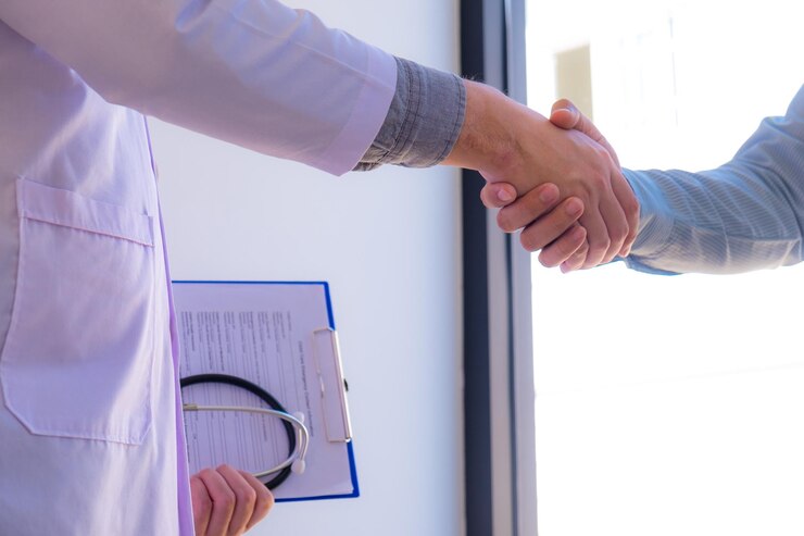 midsection doctor patient shaking hand while standing clinic 1048944 1519324