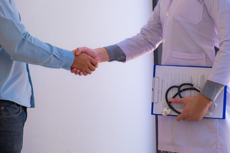midsection doctor patient shaking hand while standing clinic 1048944 21996856